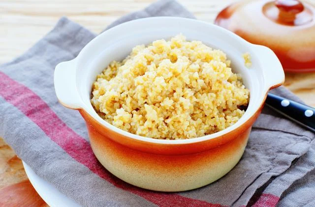 Vařený bulgur v hrnku na ubrousku.