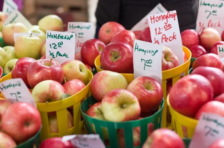 Červená jablka odrůdy Honeycrisp v barevných košíčcích na trhu.