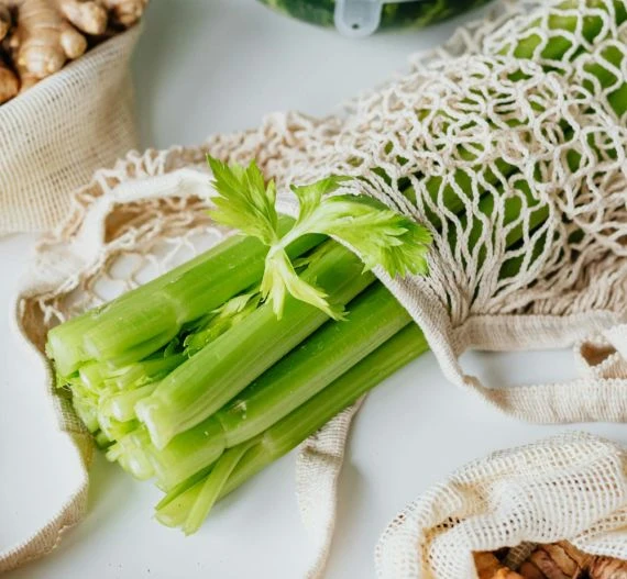 Raw celery stalks in mesh bag