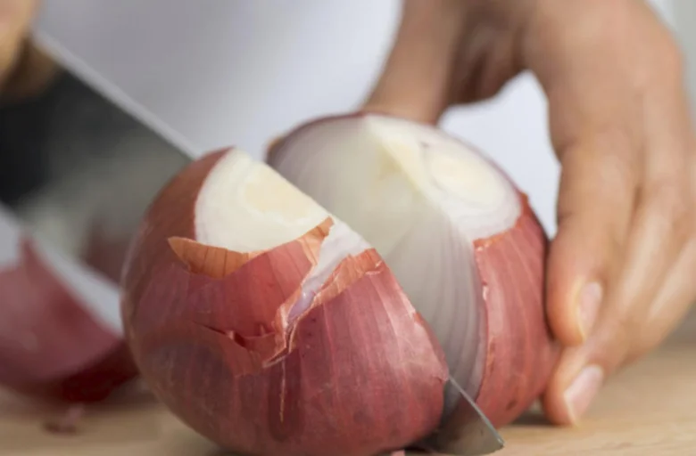 Rozkrojovaná červená cibule, která pálí oči při řezání.