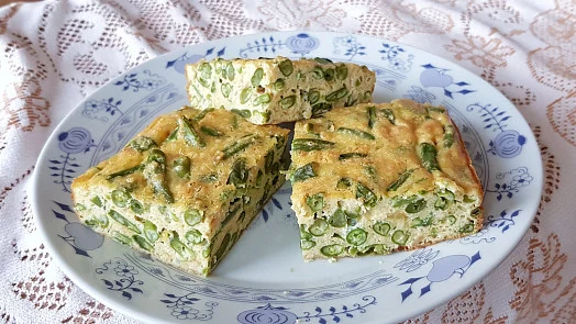 Tři kousky zeleninového omletu ze zelených fazolí na talíři.