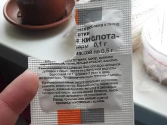 Balení kyseliny jantarové pro přidání do půdy s rostlinami na pozadí.