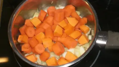 Nakrájená mrkev s cibulí v hrnci na vaření.