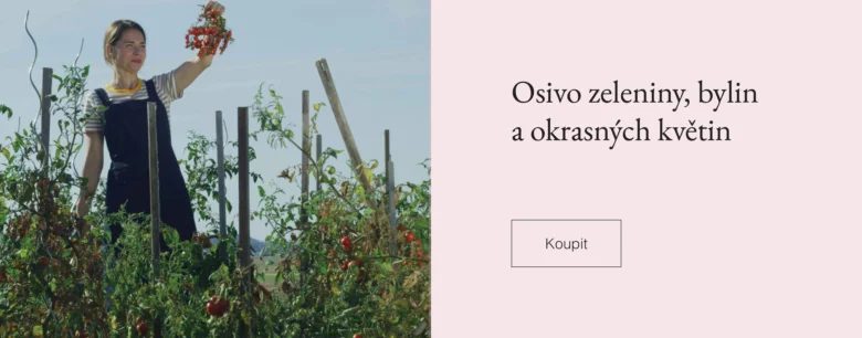 Žena drží květiny mezi rostlinami v zahradě.