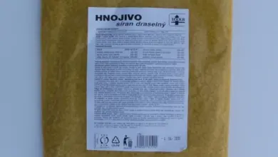 Balík síranu draselného hnojiva na zahradě s českým štítkem.